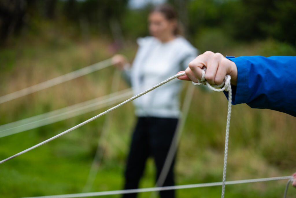 Person som holder tau under en aktivitet i teambuilding
